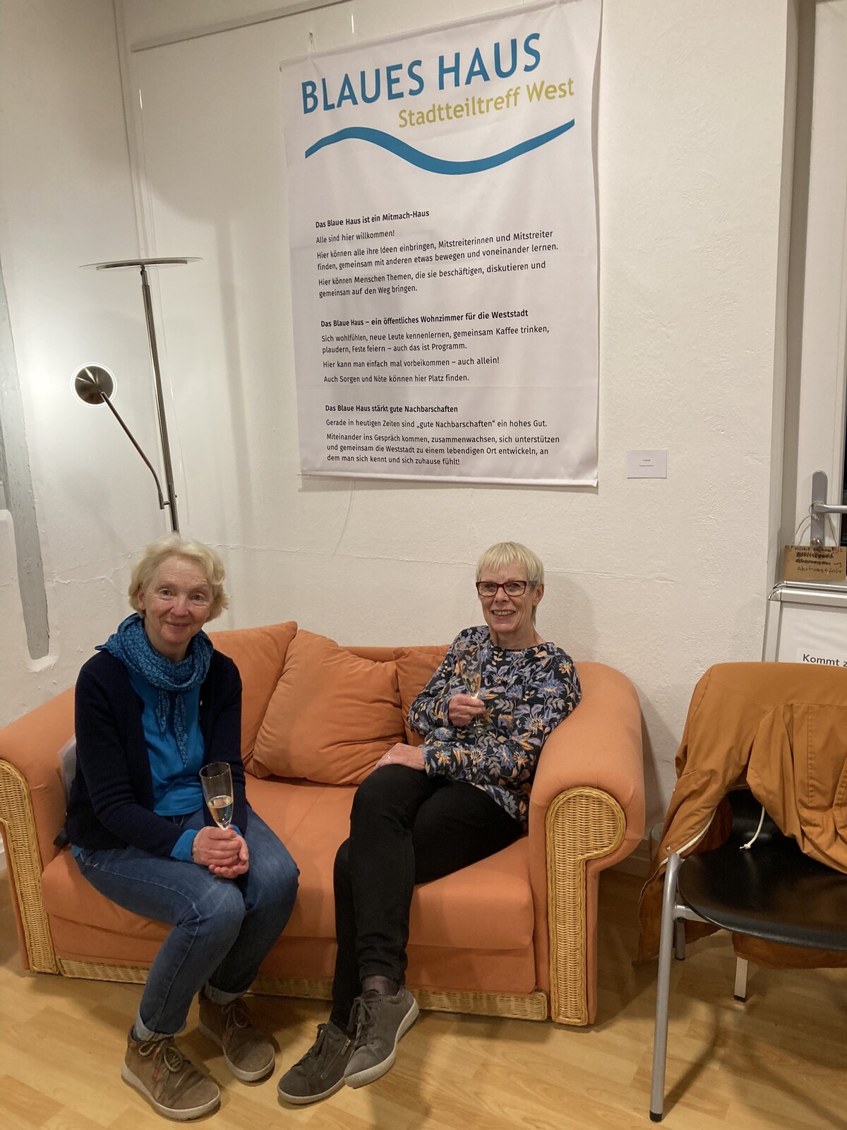 zwei lachende Frauen sitzen auf einem Sofa